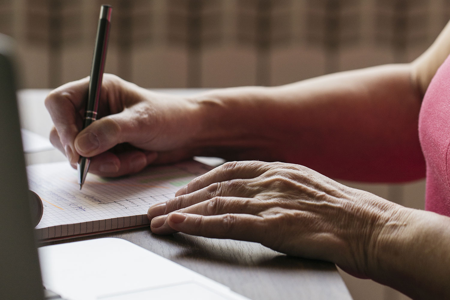 femme en train de rédiger quelque chose avec un stylo sur un livre